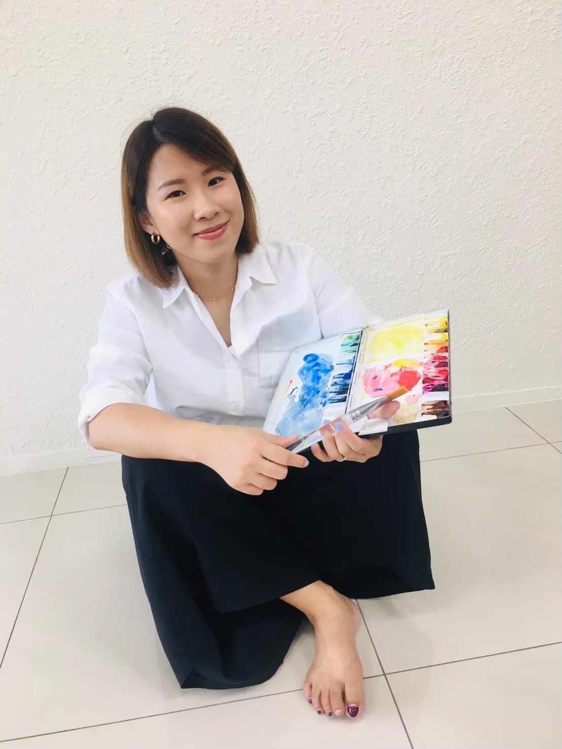 吉兒手持水彩本與畫筆
